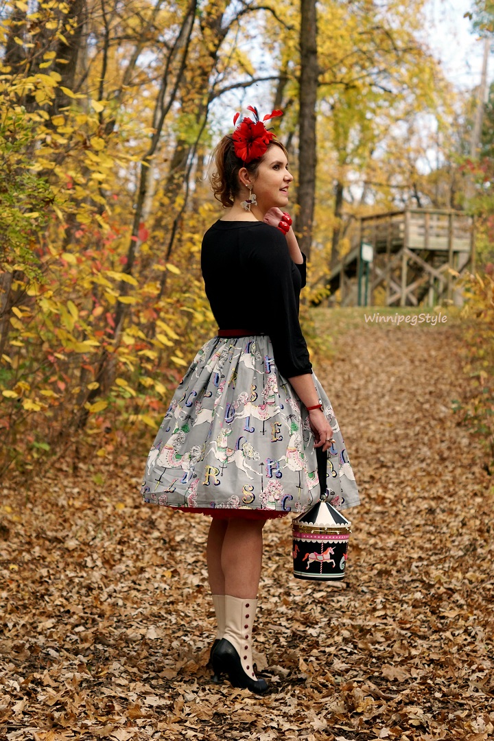 Winnipeg Style Fashion Consultant, BB and B circus carousel watch, Etsy carousel print retro vintage skirt, Nygard, Kate Spade New York Flavor of the month Carousel bag wristlet, old fashioned, Precis petite red feather fascinator, Fabcessories carousel horse earring, Fluevog spat victorian boots, unique fashion, quirky fashion 